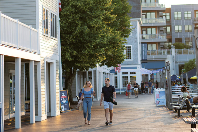 Couple walks down the streets of Quincy, MA near the Safe Harbor Marina.
