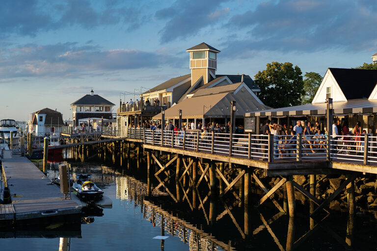 People gather along the patio at Safe Harbor Marina in Quincy, MA.