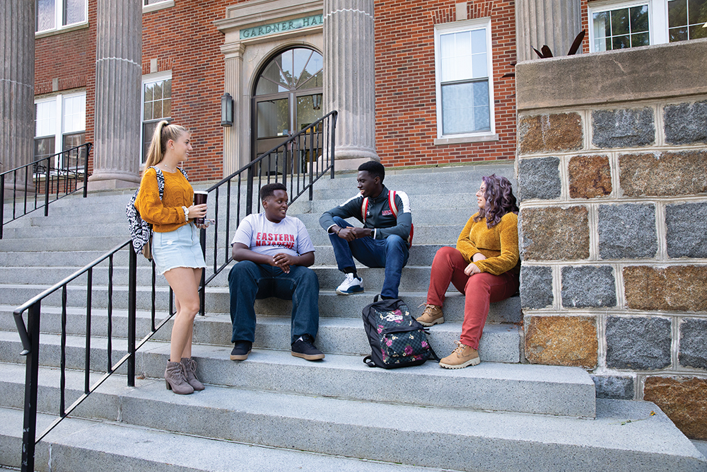 Students sit on the steps outside of Eastern Nazarene College in Quincy, MA.