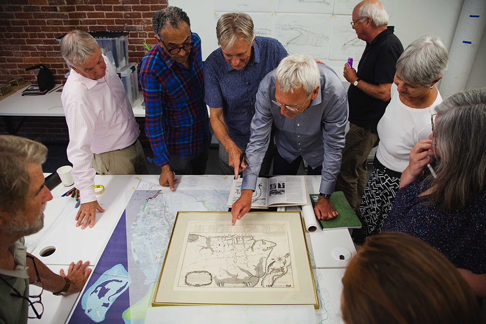 People gather around a table looking at a map at The Water Institute of the Gulf in Baton Rouge, LA. 