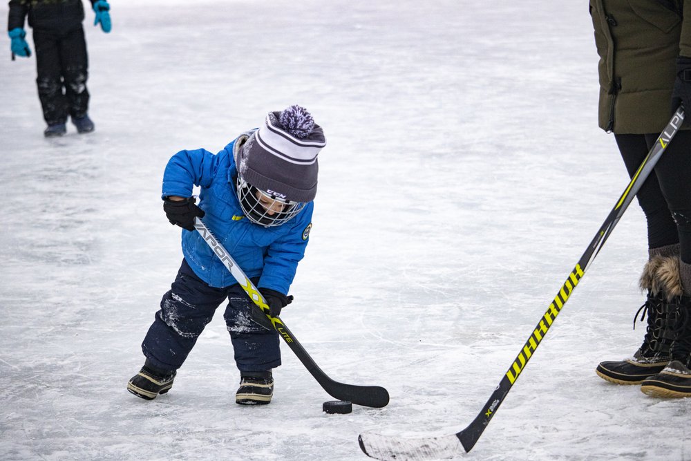 Kids play pond hockey on a frozen pond in Minneapolis, MN.