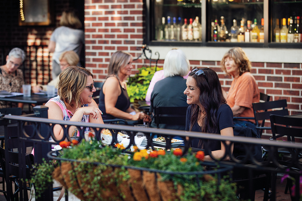 Women chatting outside on a patio at a local restaurant in the Cedar Falls area.