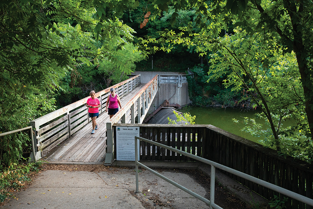 Visitors walk across a bridge aboove the dam at Radnor Lake State Park in Nashville, Tennessee.