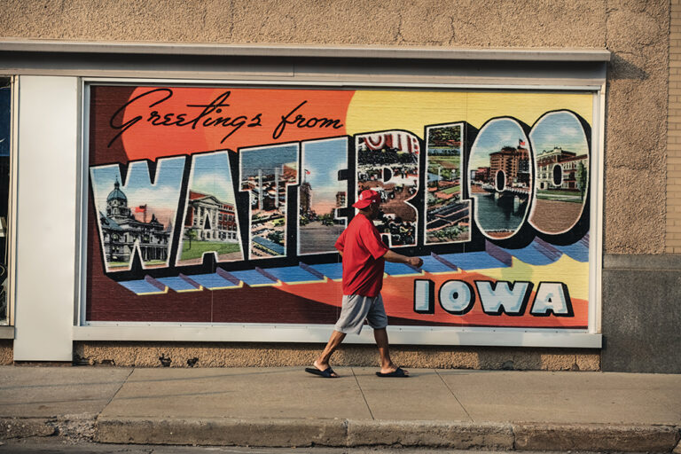 Visitors walk past a mural in downtown Waterloo, Iowa.