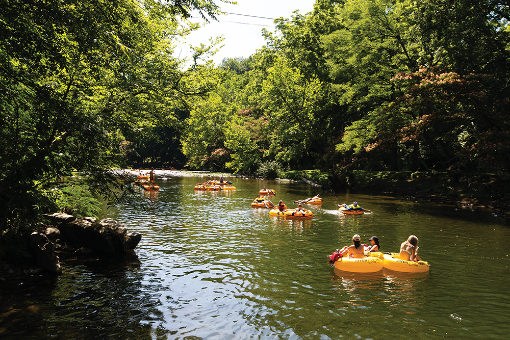 Visitors float down the Little River on tubes past the Swininging Bridge on a sunny afternoon in Townsend, Tennessee, which is located in Blount County.