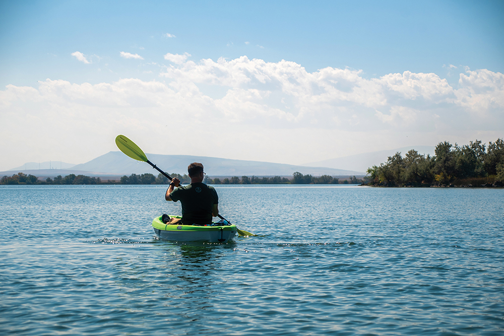 Man rides a kayak on Lake Walcott in Southern Idaho. 