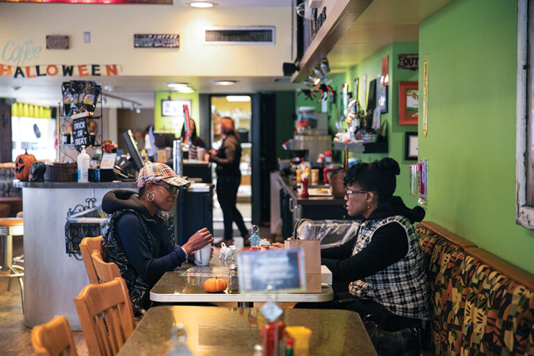 ReShonda Young talks with business owner Rosie Daniel of LuLit’s Hair Essence at Newton’s Paradise Cafe in Waterloo, Iowa, U.S. October 27, 2021. Photo by Brenna Norman for the Center for Public Integrity.