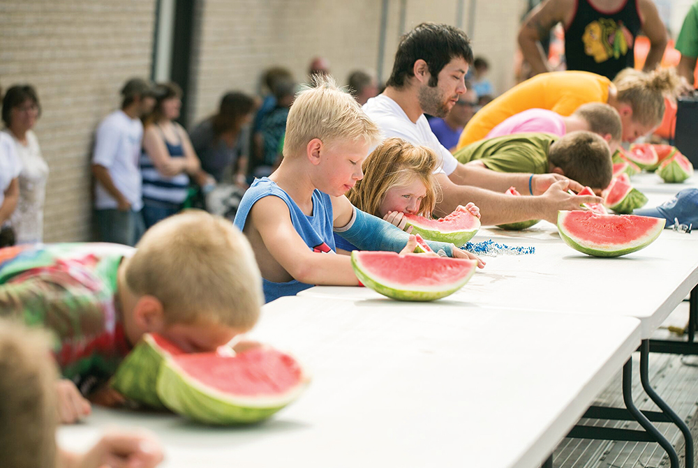 Children eating watermelon at the Dike Watermelon Days in the Cedar Valley region of Iowa.