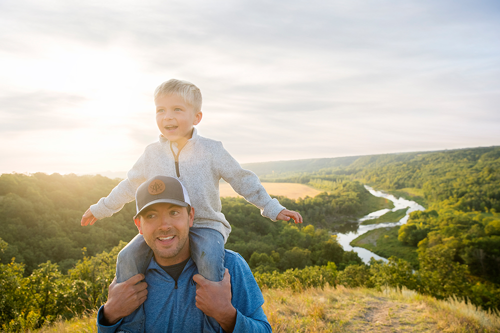 Families can enjoy all four seasons in North Dakota. A father and son are pictured hiking Pembina Gorge.