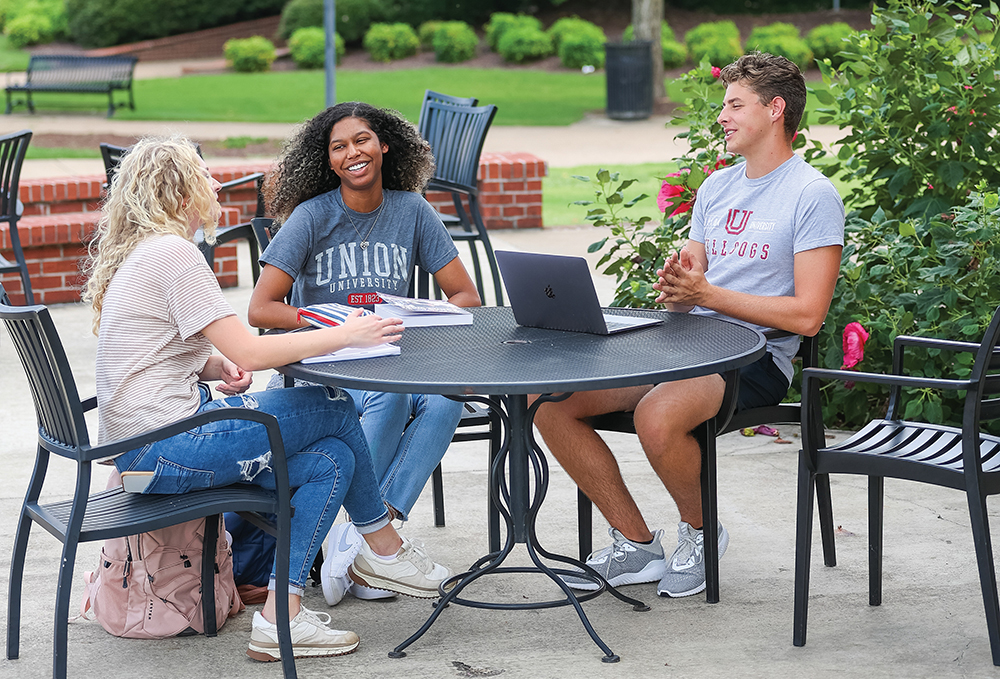 Students sit together at an outside table on the Union University campus in Jackson, TN.