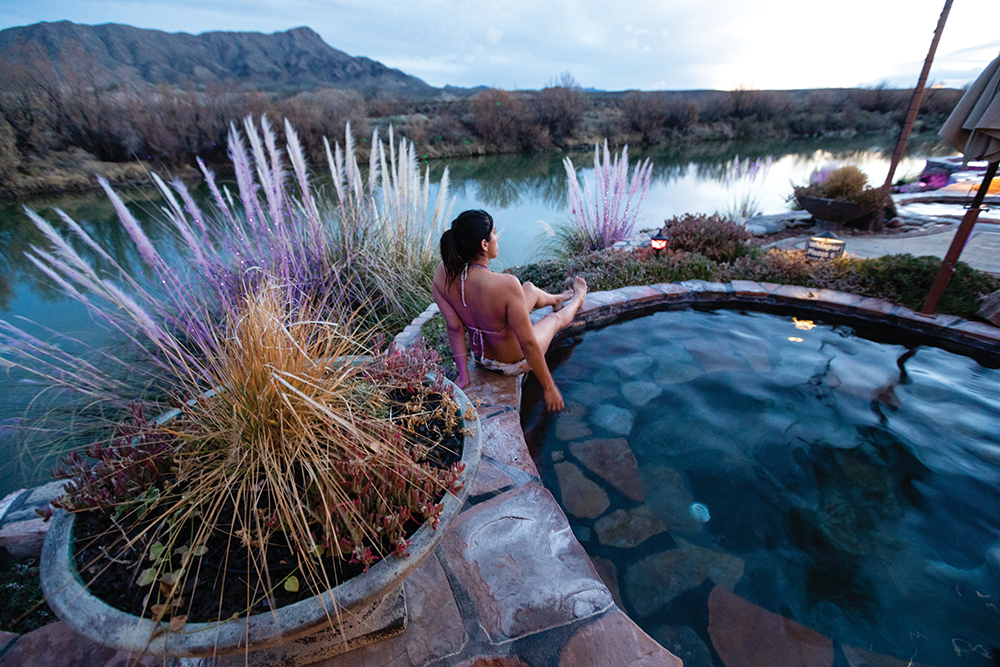 Visitors enjoy the Common Hot Springs Pools with views of the Rio Grande River and the Caballo Mountains at Riverbend Hot Springs in downtown Truth or Consequences, New Mexico. Riverbend Hot Springs is part of the Hot Springs Bathhouse Historic District Healing Waters Trail.