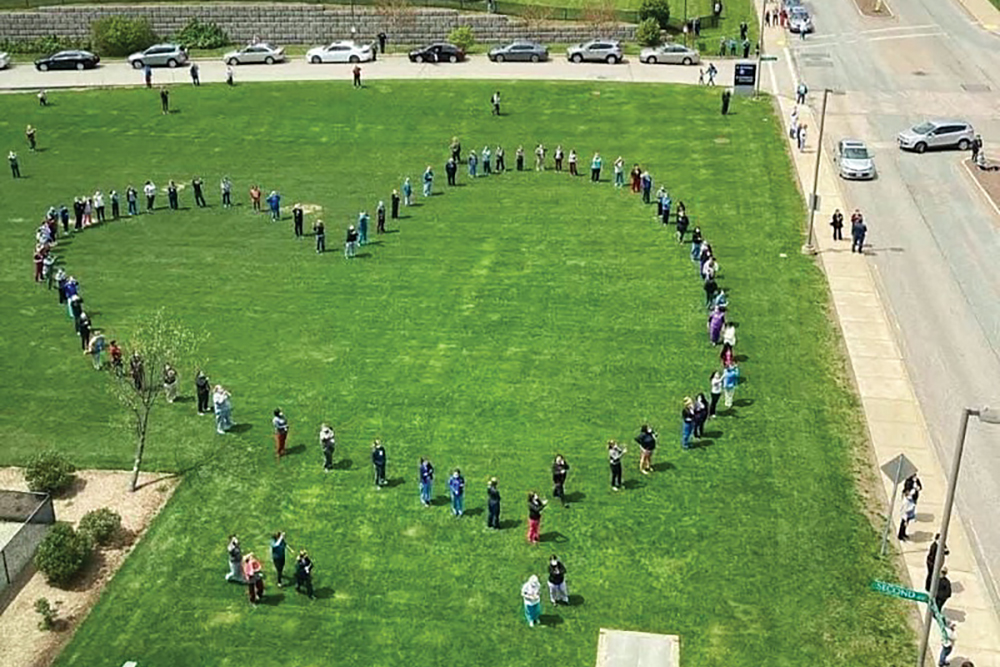 Nurses stand in the shape of a heart outside of UMass Memorial Health in Worcester, MA.