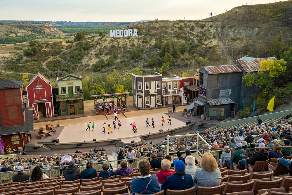 Crowd attends a showing of the 7. Attend the Medora Musical in the Burning Hills Amphitheater in North Dakota. 