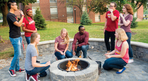 Students gather around a fire pit at Coe College in Cedar Rapids, Iowa.