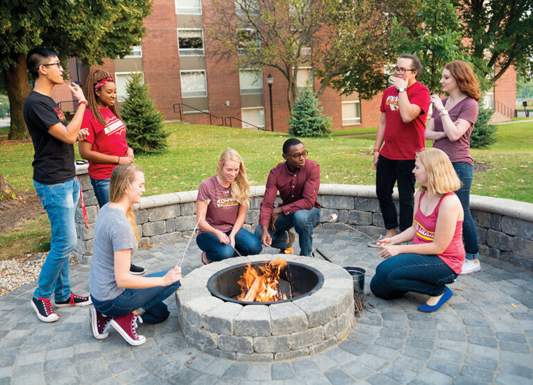 Students gather around a fire pit at Coe College in Cedar Rapids, Iowa.
