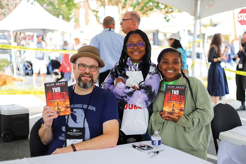 Two children pose with an author at Bookmarks NC in Winston-Salem, NC.