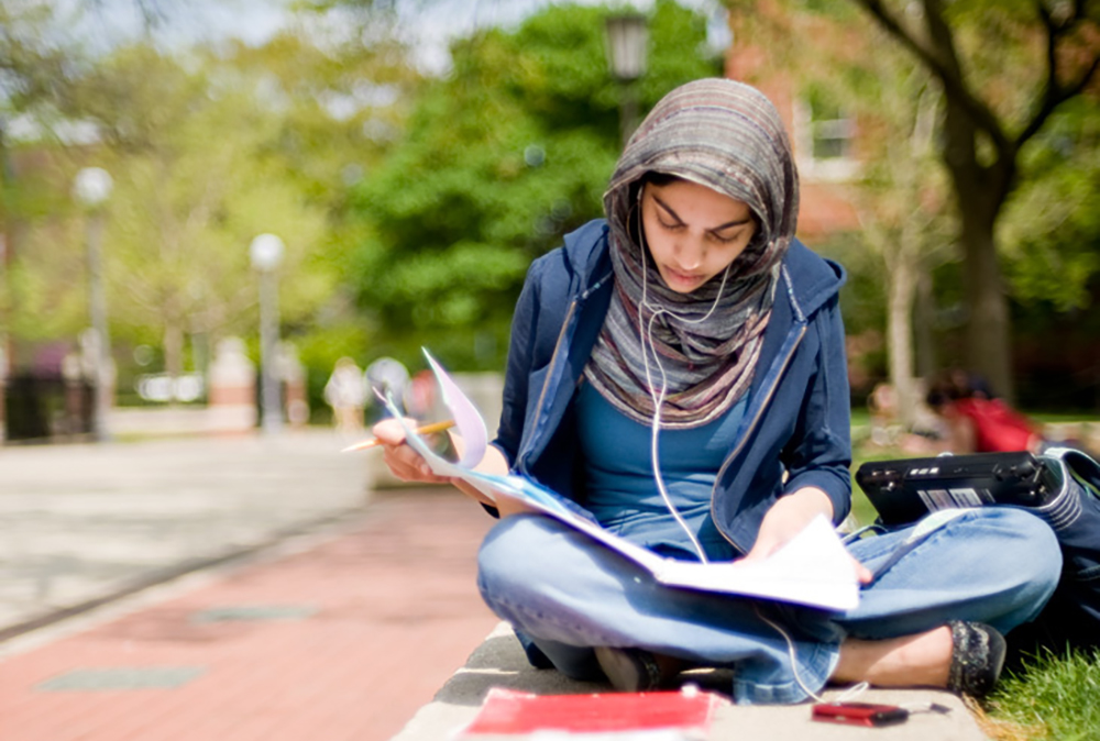 student wearing headphones and studying outside the Union on the Quad at the University of Illinois at Urbana-Champaign
