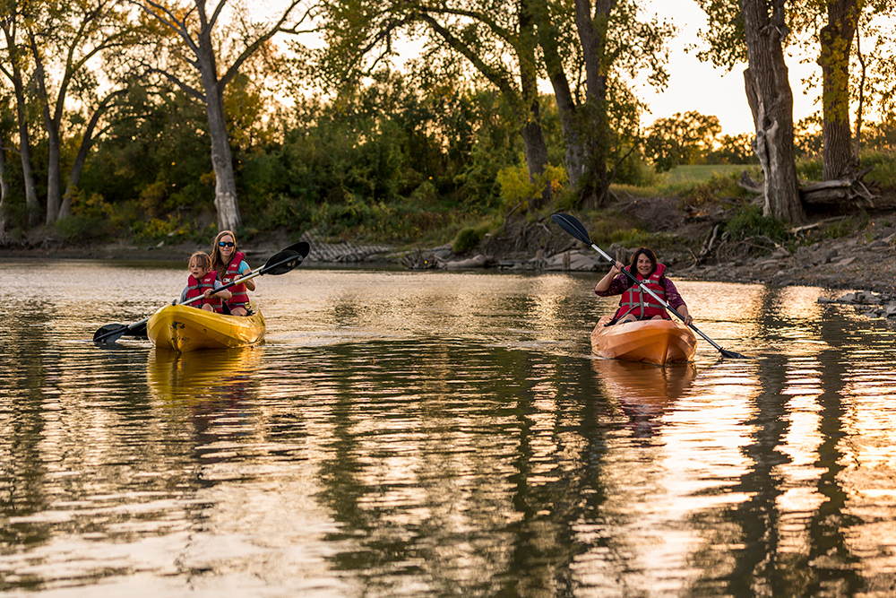 People Kayaking at Sunset on the Red River in North Dakota.