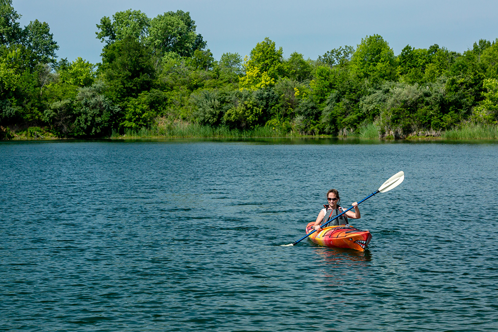 Woman kayaking along River Bend in Champaign, IL.