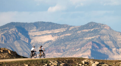 Mountain bikers travel an easy trail into grandiose scenery near Fruita, CO.