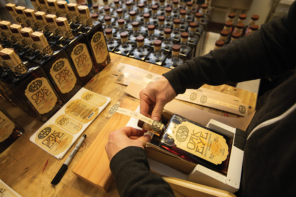 Carus Waggoner applies the Oak Eye label to a bottle of bourbon at Second Sight Spirits in Ludlow. Ludlow is located in the Northern Kentucky region.