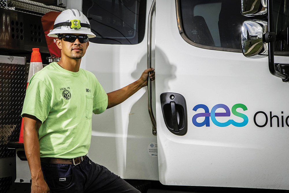 Employee of AES Ohio electric company standing next to his work truck