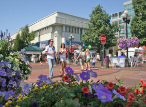 People shopping in downtown Eugene, OR, on a sunny day. From access to outdoor activities and oodles of things to do, Eugene has much to offer residents, making it one of the best places to live in the U.S.