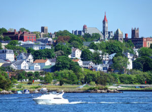 A view of Fall River, MA, from the river, with its quintessential New England scenery. Two interesting tidbits about Fall River: It was home to the infamous Lizzie Borden, and it also is a hub for Portuguese immigrants, with about half of the city's residents claiming Portuguese ancestry.