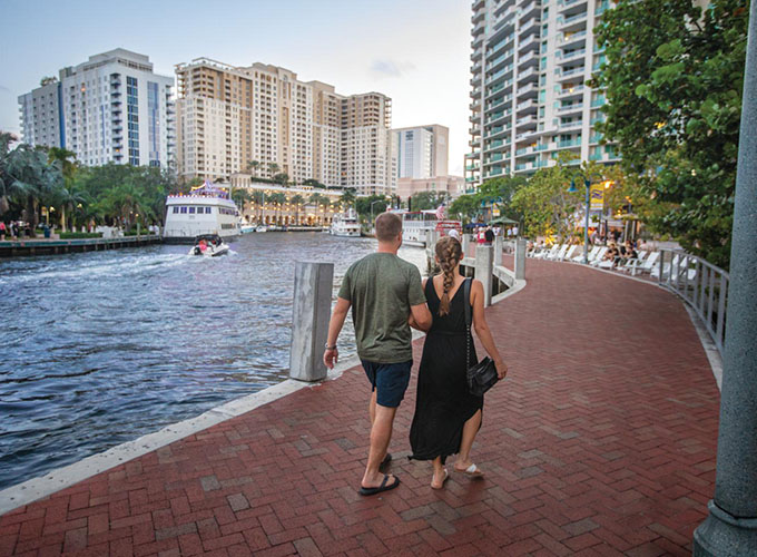 Visitors stroll along the New River at Riverwalk Fort Lauderdale in downtown Fort Lauderdale, FL, one of the best places to live in the U.S.