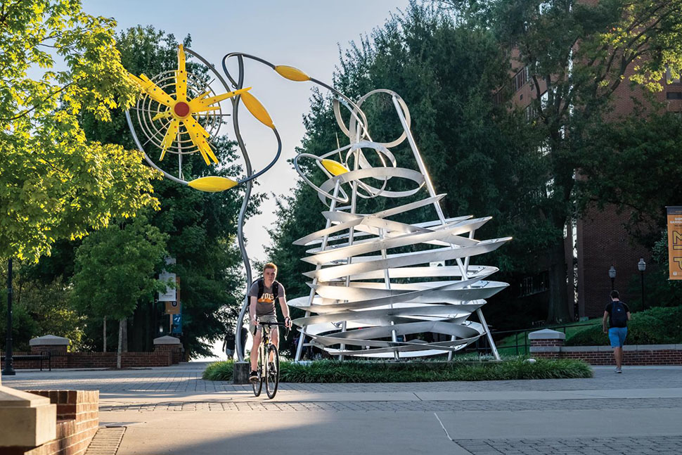 Students walk past a giant sculpture on the campus of the University of Tennessee in Knoxville, TN. Knoxville offers arts and culture and endless dining and entertainment options, as well as nature and scenery.