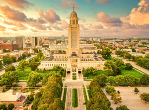 An aerial view of the Nebraska State Capitol against the Lincoln, NE, skyline. As one of the best places to live in the U.S., the capital of Nebraska offers a low cost of living and a high quality of life.