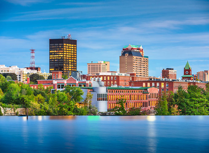 The Manchester, N.H. skyline on the Merrimack River at dusk. As one of the best places to live in the U.S., Manchester ranks high for education.