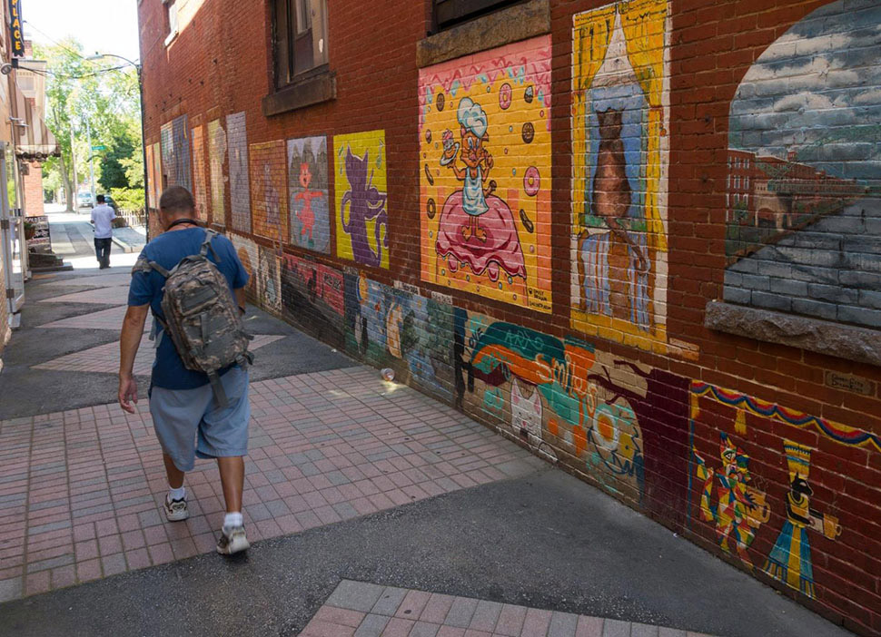 Cat alley in Manchester, NH, is lined with colorful murals of cats. Manchester has an artistic side and amenities like museums and theaters make the city one of the best places to live in the U.S.