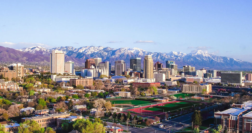An aerial view of Salt Lake City, UT. Surrounded by mountains, Salt Lake City has a magnificent backyard playground braided with hiking and biking trails and ski slopes.