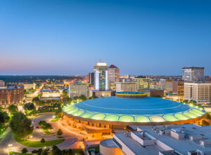 An aerial view of the Wichita, KS, downtown skyline at dusk. Wichita's Western past is balanced by a vibrant downtown with a rich live music scene and an affordable cost of living, making it one of the best places to live in the U.S.