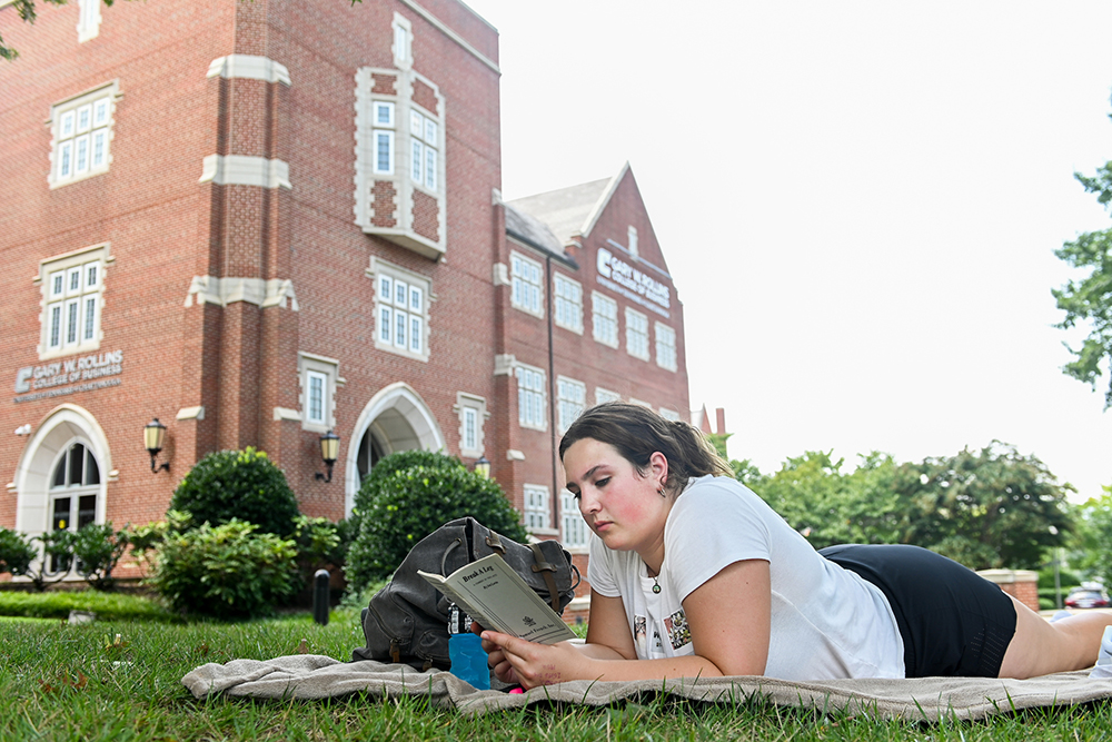 A student reads on the lawn of the UTC campus.