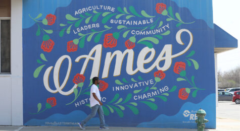 Walking past a mural by artist Lauren Gifford in downtown Ames, Iowa.