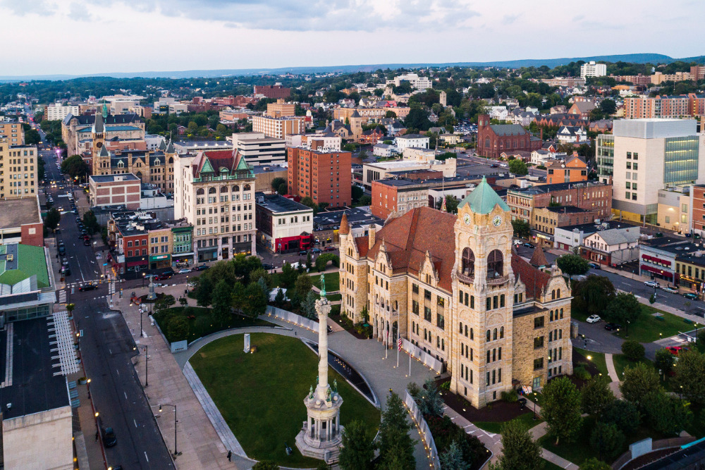 The aerial view shows City Hall and Downtown District of Scranton, PA, at sunset. 