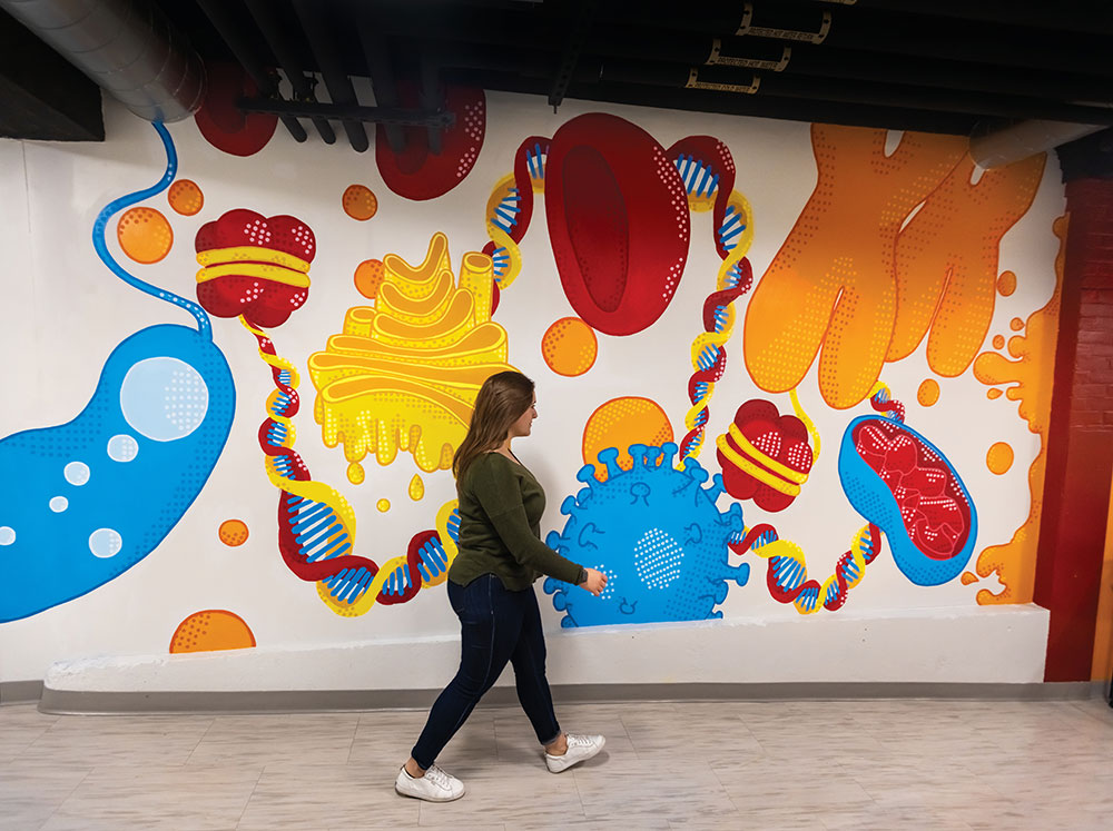 A colorful biomedical-themed mural decorates a wall at MBI in Worcester, MA