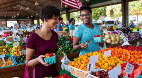 Women shopping at Moore's Produce Booth at the North Carolina State Farmers Market in Raleigh, North Carolina.