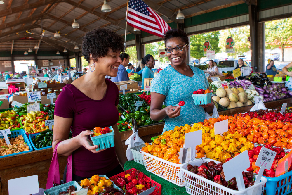 Women shopping at Moore's Produce Booth at the North Carolina State Farmers Market in Raleigh, North Carolina.