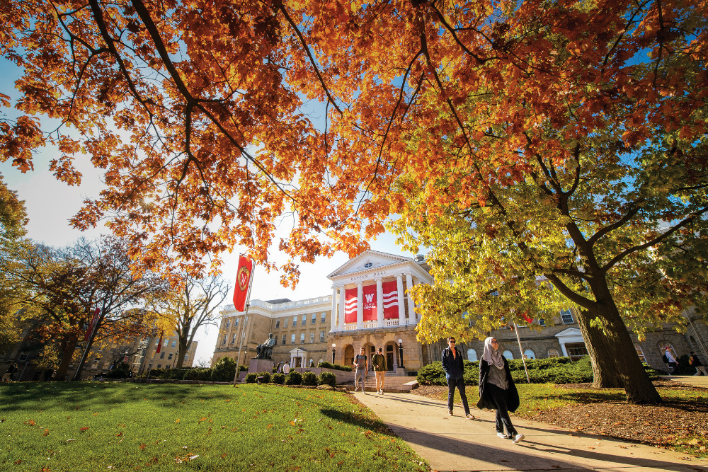 Students walk along a colorful tree-lined sidewalk outside Bascom Hall in fall at the University of Wisconsin-Madison on Nov. 4, 2016. (Photo by Bryce Richter / UW-Madison)