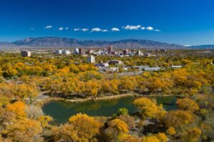 Albuquerque, New Mexico, during autumn with the downtown skyline and the Sandia Mountains in the distance.