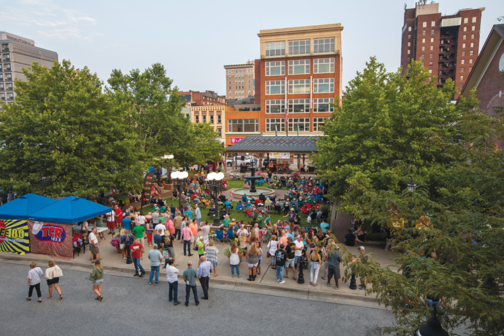 A crowd gathers to listen to music during an outdoor concert series at Pullman Square in downtown Huntington, West Virginia.