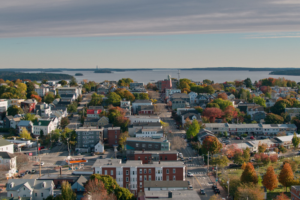 An aerial shot of residential streets in Portland, Maine, looking towards the islands in Casco Bay.