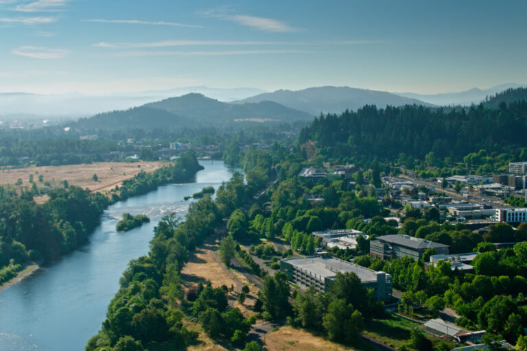 Aerial shot of the Willamette River flowing through Eugene, Oregon on a sunny day in summer.