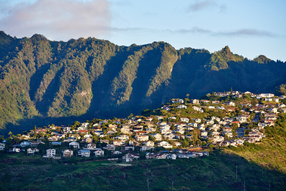 An aerial view of Kaneohe, Hawaii, and the mountain range that overlooks the town. 