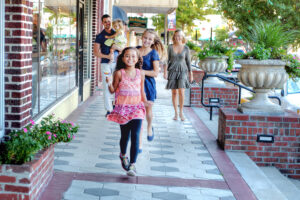 A family strolls along shops in DeLand, FL.
