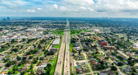 Aerial view of Interstate 10 bisecting Metairie, Louisiana, with New Orleans in the distance.