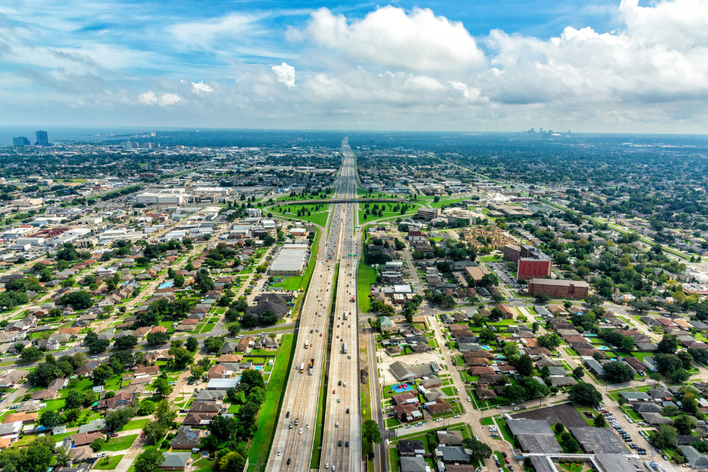 Aerial view of Interstate 10 bisecting Metairie, Louisiana, with New Orleans in the distance. Metairie is a best place to live in Louisiana.